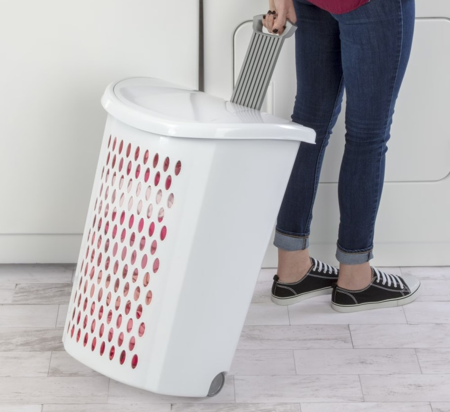 person pulling white rolling laundry basket