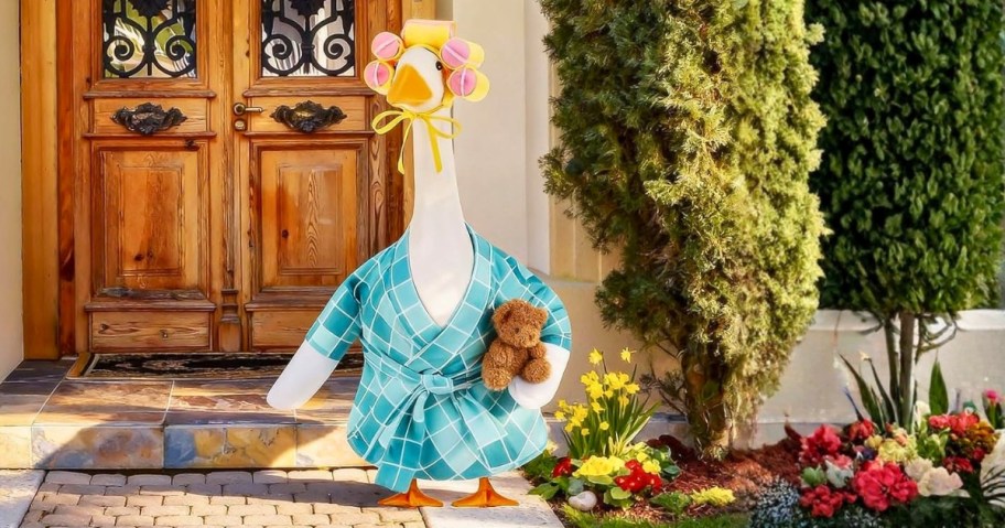 a decorative porch goose with a robe and wig with curlers outfit on a front porch