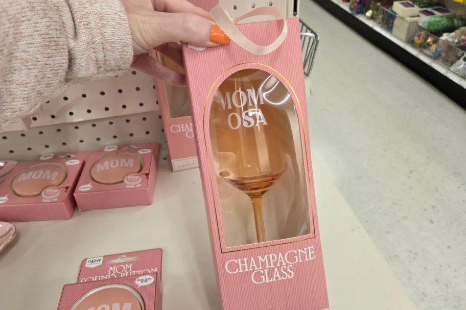 hand holding box with momosa champagne glass 