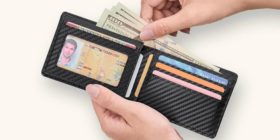 hand taking money out of black wallet 