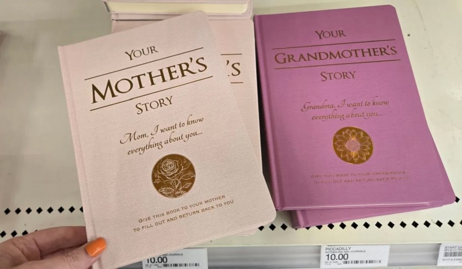 hand holding mother's journal book on store shelf next to stack of grandma books