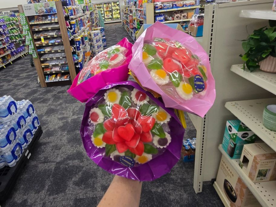 Hand holding 3 CVS candy bouquets