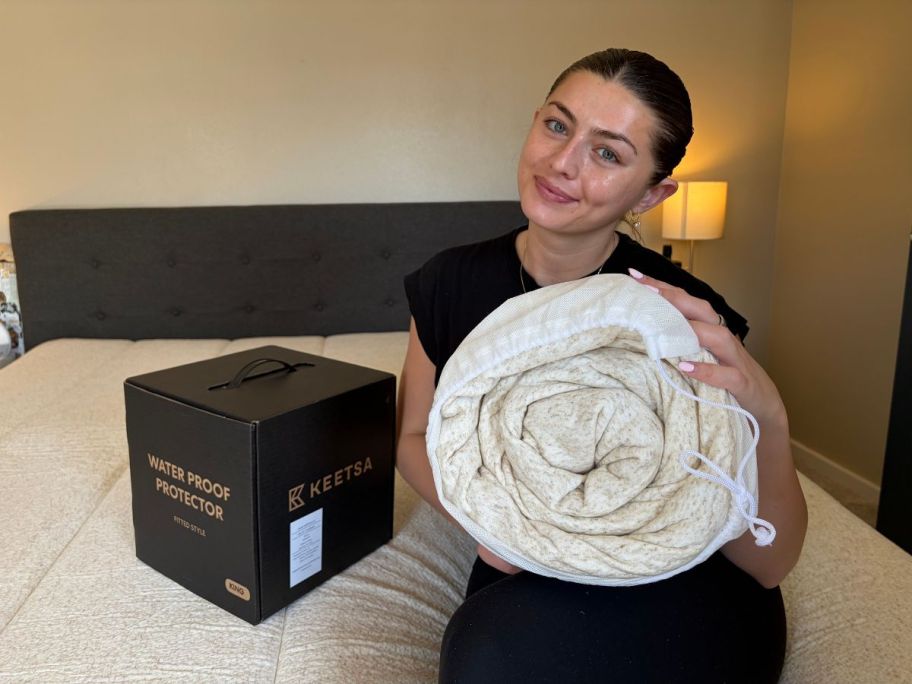 saylor holding Keetsa Waterproof Mattress Protector Fitted Sheet