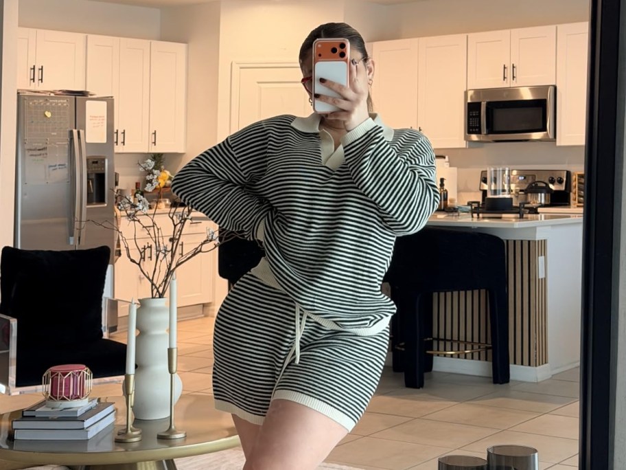 woman in striped lounge set taking mirror selfie