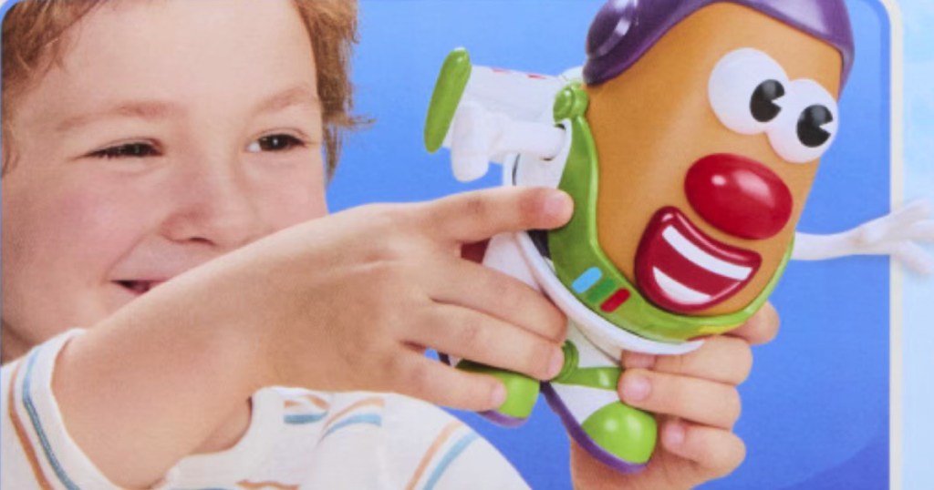 little boy holding toy story potato head