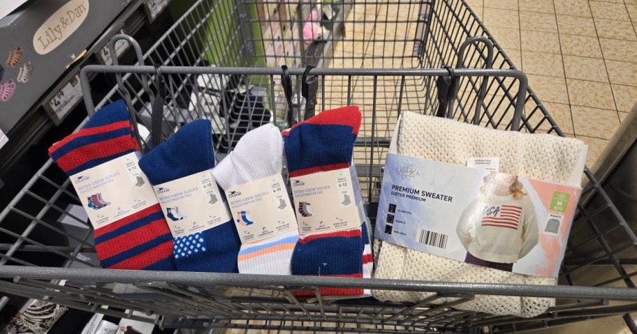 Shopping cart with four pairs of colorful socks and a premium sweater. Socks have red, blue, and white patterns; sweater is cream-colored.