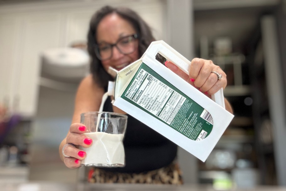woman holding carton with handle pouring milk