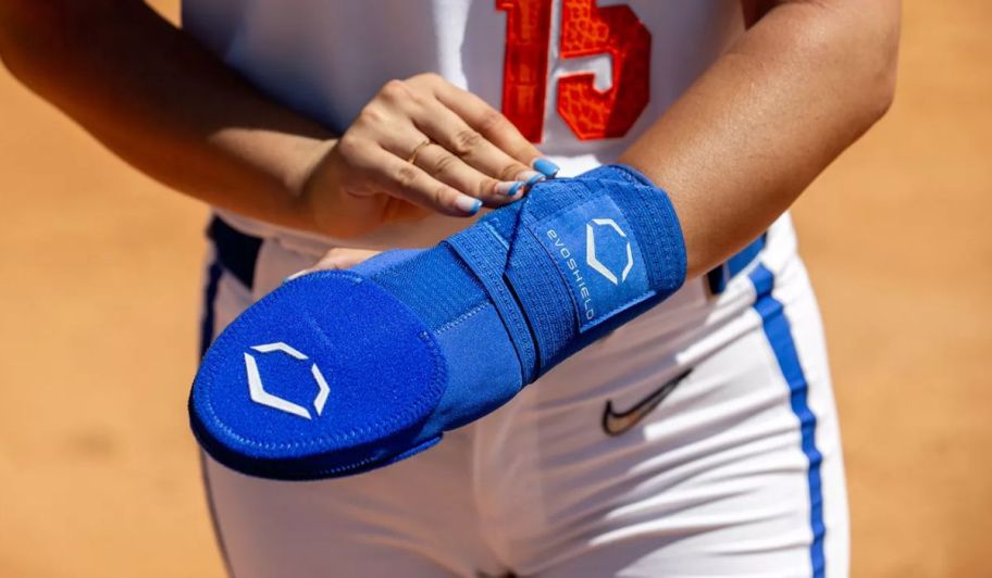 Hand holding a blue baseball mit