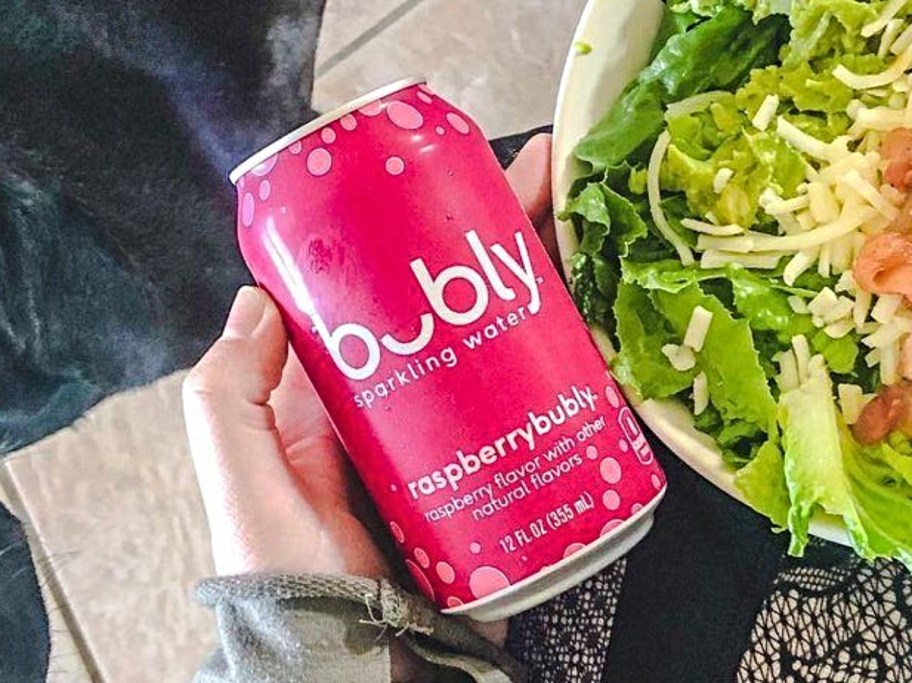 holding a can of raspberry bubly