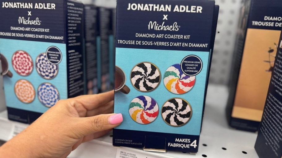 a womans hand holding a Jonathan adler diamond art kit