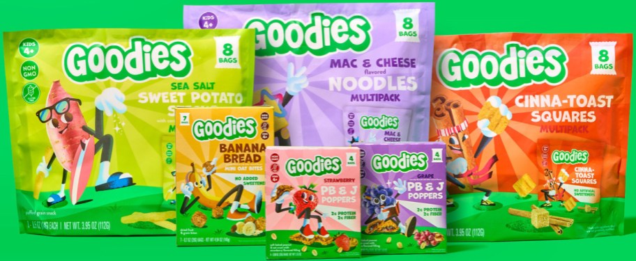 Colorful packaging for "Goodies" snacks on a green background, featuring cartoon characters and flavors like sweet potato, banana bread, and mac & cheese.