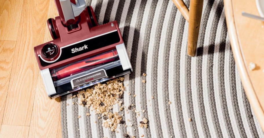 shark stratos vacuum picking up food debris from a rug