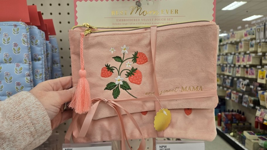 hand holding pink velvet mama pouches on store shelf