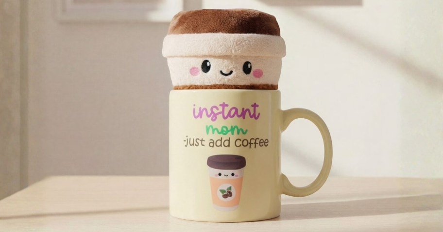 a coffee mug with a quote on it and matching coffee cup plush sitting in it